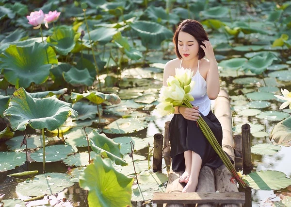 Tạo dáng với bó sen sau lưng
